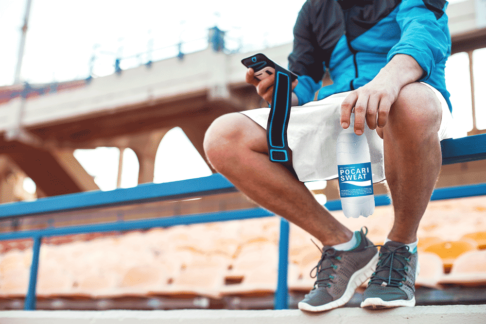 Image of a sportsman holding a bottle of Pocari Sweat.