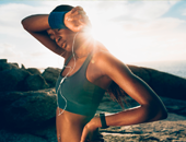 A young lady wiping sweat off her face while exercising