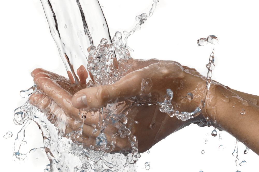 An image of water being poured on a persons hand.